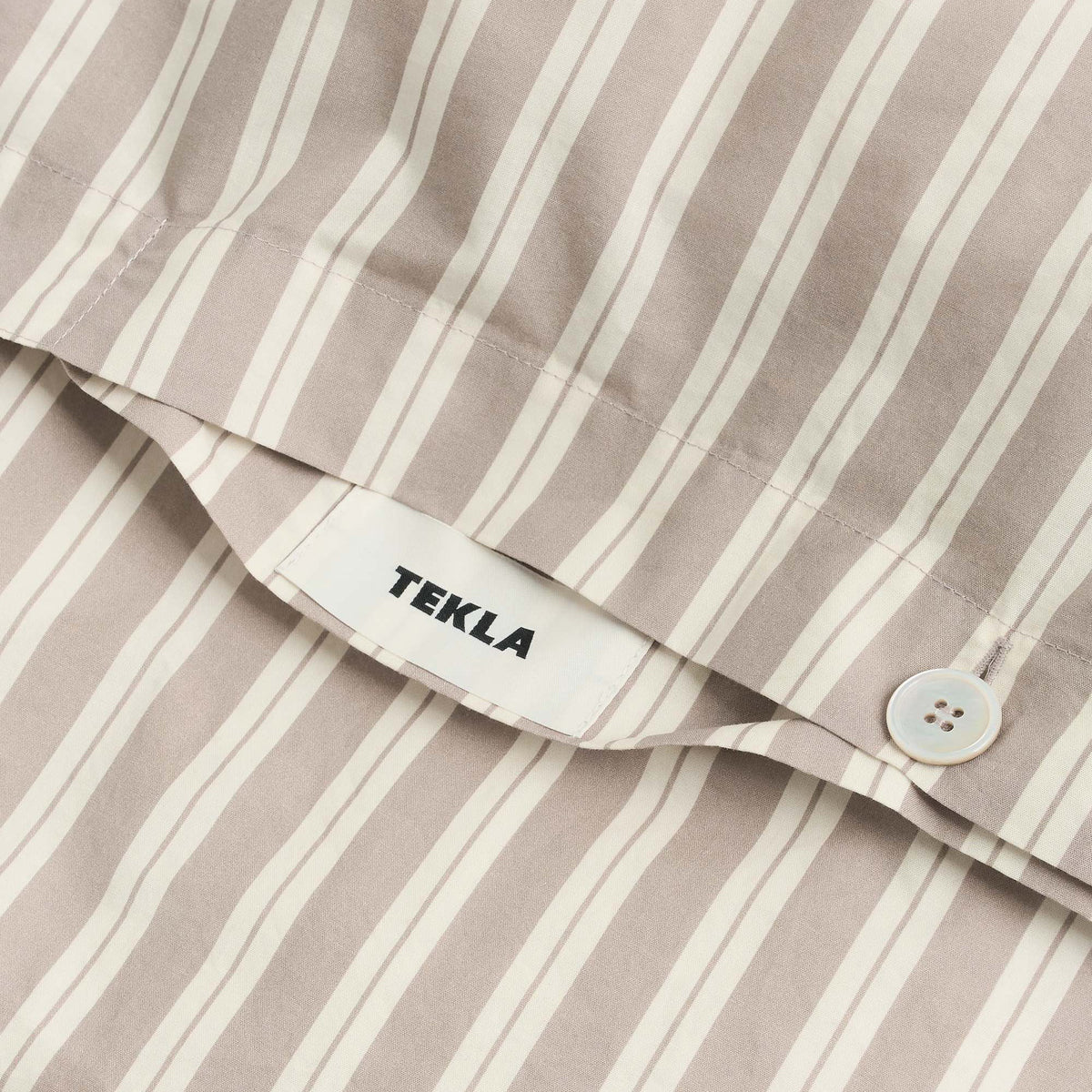 Tekla Percale Double Duvet Cover in Clay Stripes, close-up of corner button closure and TEKLA label