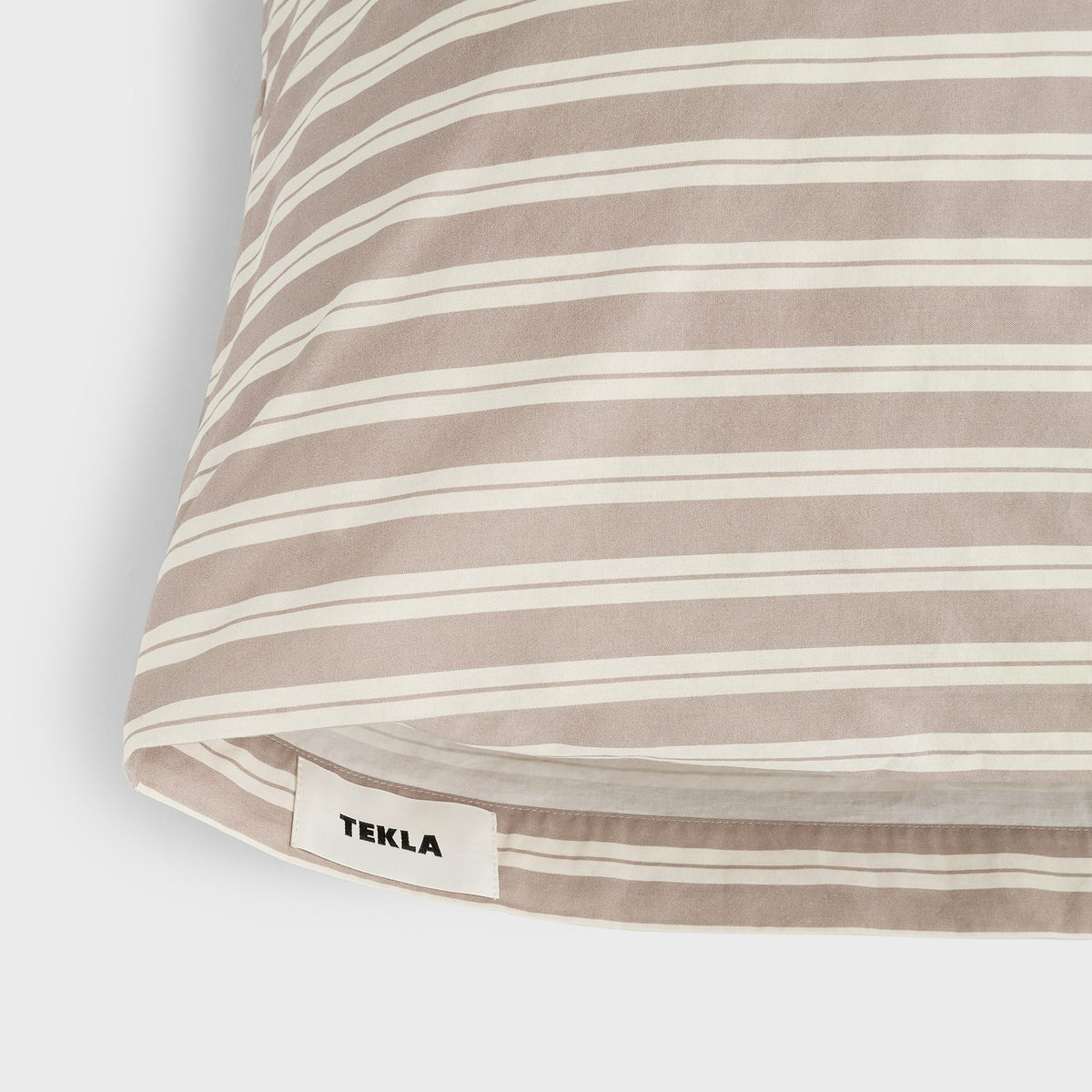 Tekla Percale Pillow Sham in Clay Stripes, close-up of corner with woven TEKLA label