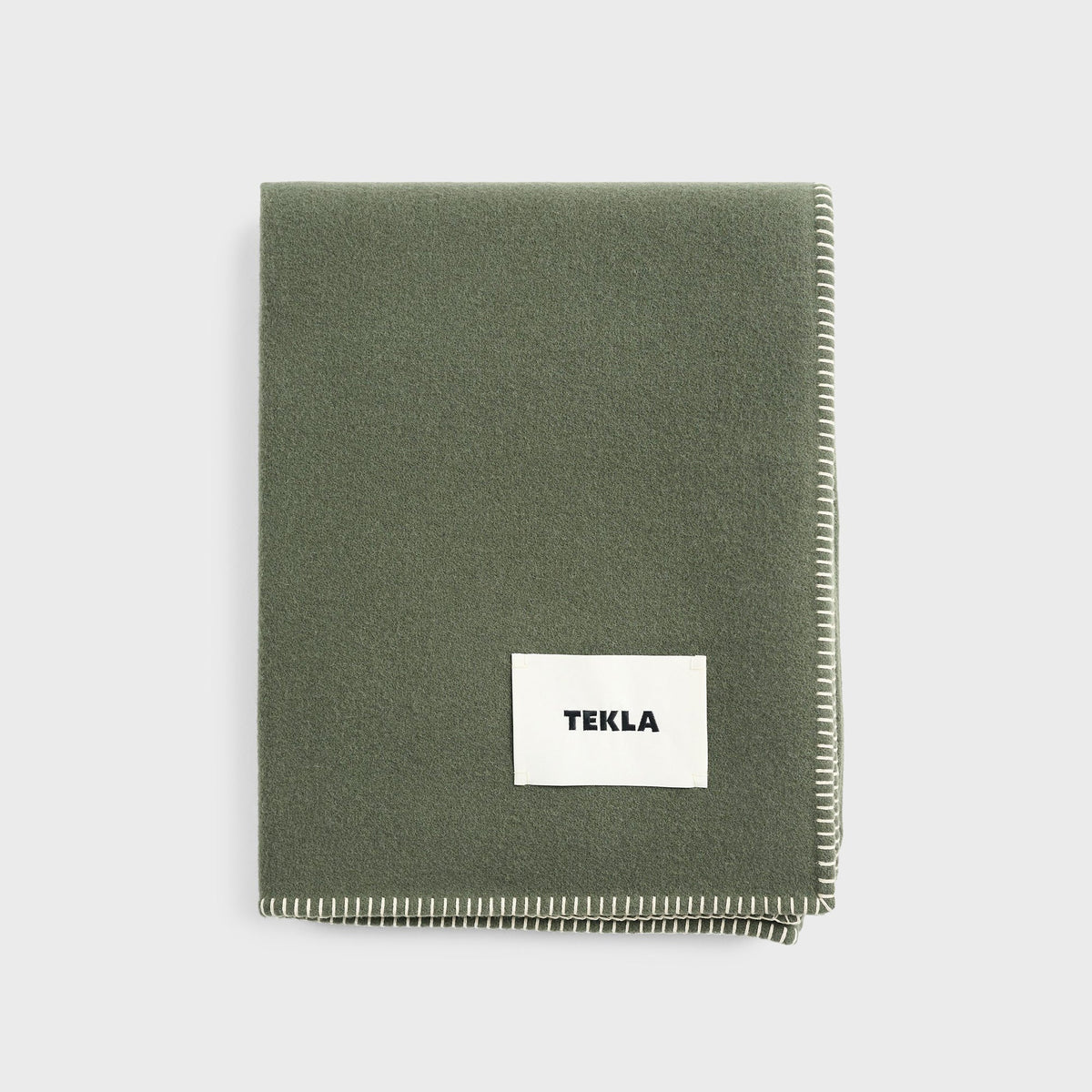 Tekla Lambswool Blanket in Willow, folded sage green wool blanket with TEKLA label