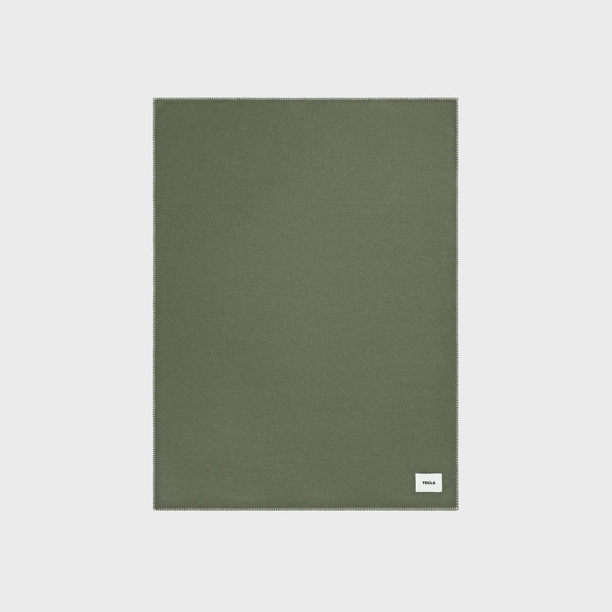 Tekla Lambswool Blanket in Willow, close-up of the solid sage green wool fabric