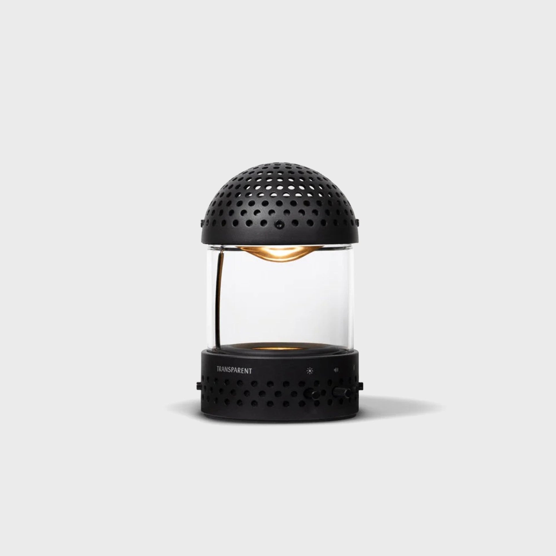 Transparent Sound Light Speaker in black showing perforated dome, carry handle and brightness and volume dial controls