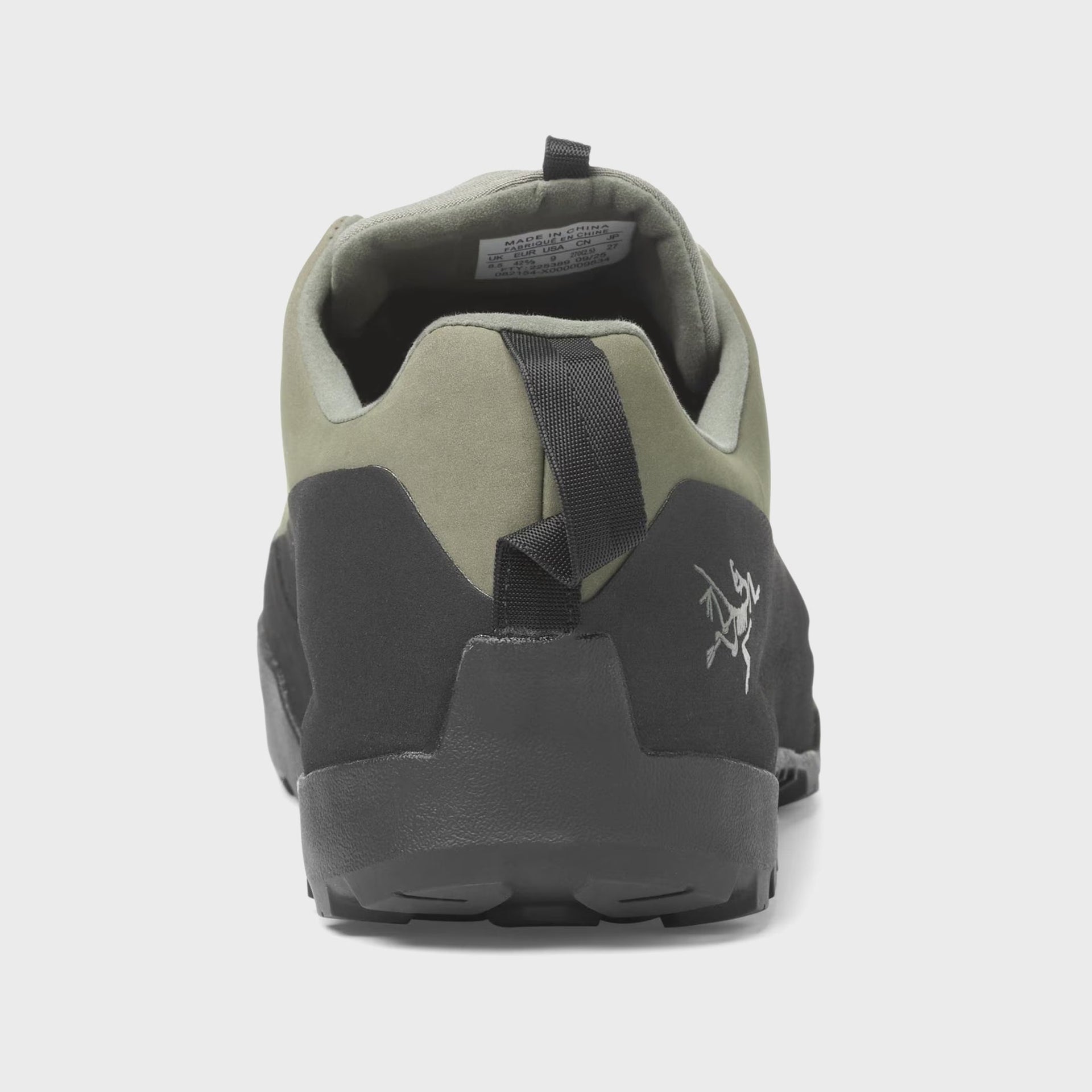 Arc'teryx Konseal approach shoe rear heel view showing pull tab and grey Arc'teryx bird logo on black overlay