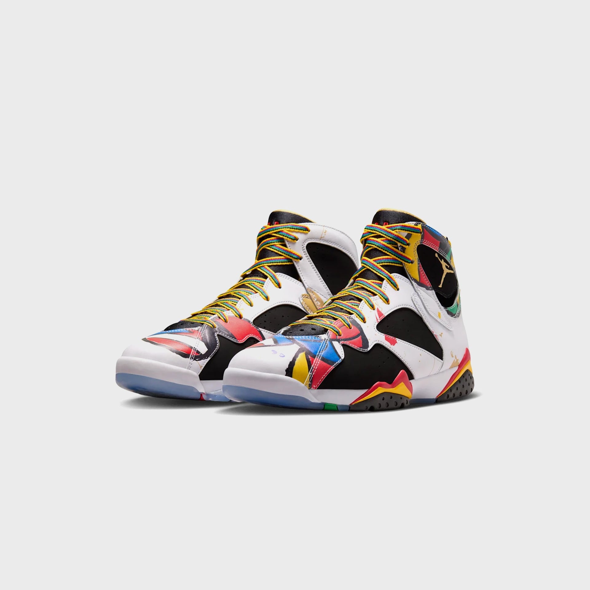 Pair of Air Jordan 7 Retro sneakers with multicolor Olympic print and rainbow-yellow laces, front three-quarter view