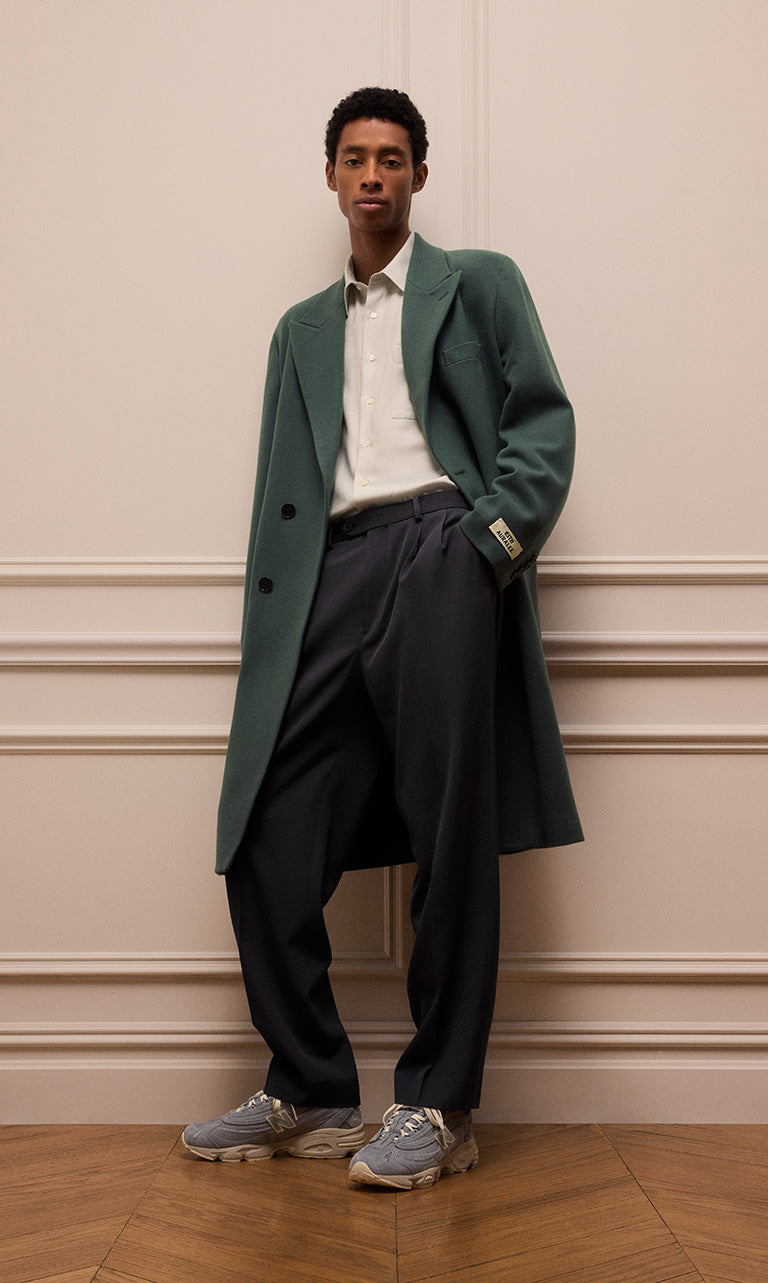 
        A model wearing a jacket, shirt, and trousers from Kith 101 for Auralee.
      
