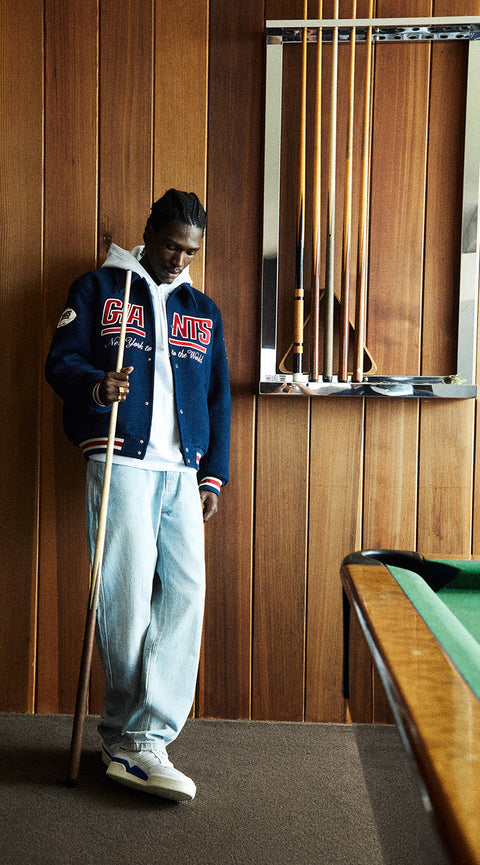 
        A model wearing the Kith for the NFL: Giants collection varsity jacket. 
      
