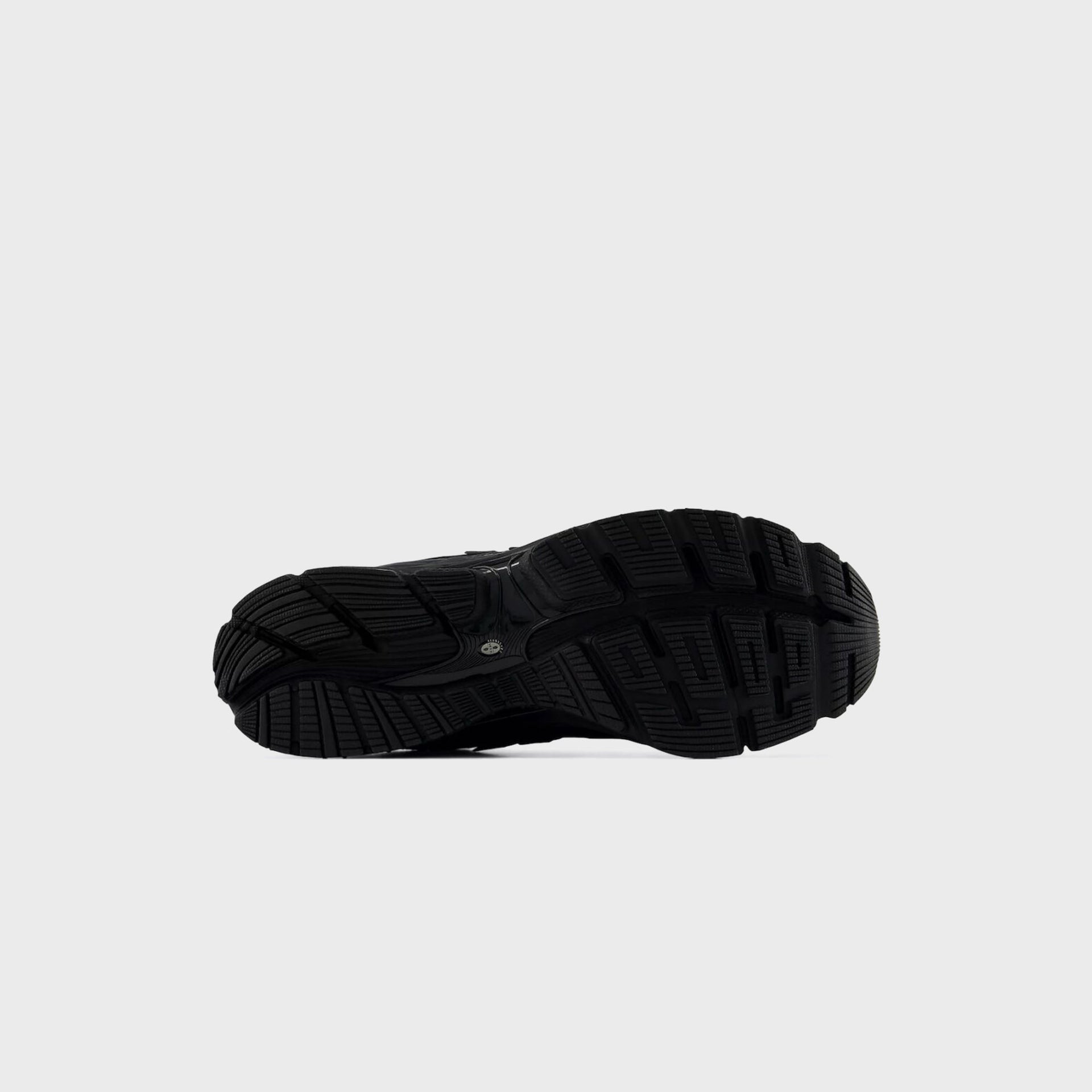 Outsole view of the New Balance 1954R Black showing its black lugged rubber sole