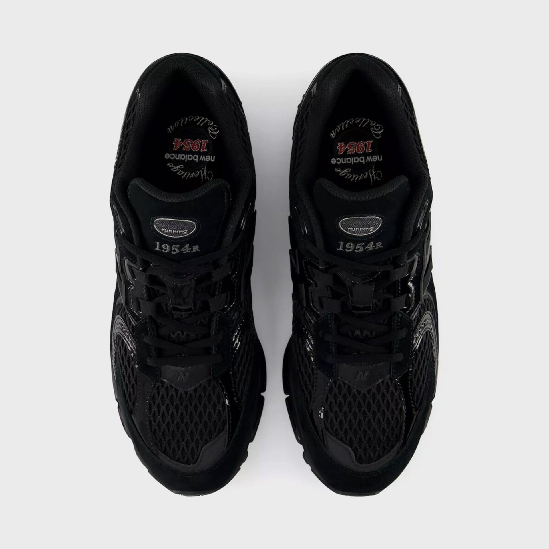 Overhead view of a pair of New Balance 1954R Black sneakers showing the black mesh and 1954 Heritage insole branding