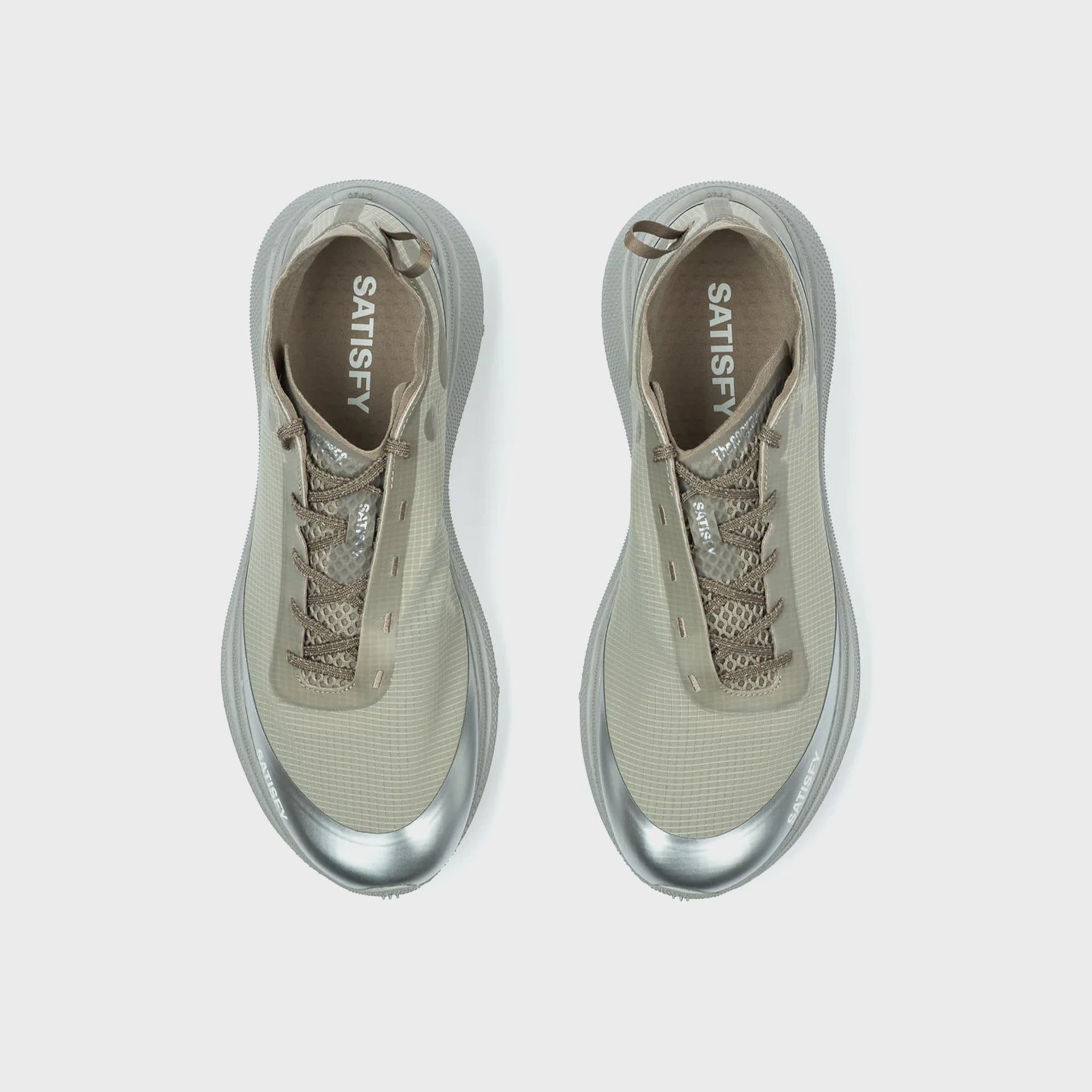 Pair of SATISFY TheROCKER sneakers in aluminum grey, top-down view showing tan SATISFY-branded insoles and crisscross laces