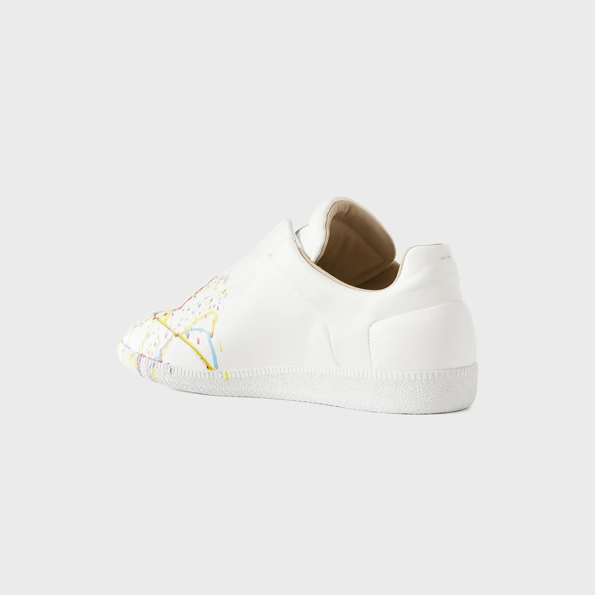 Maison Margiela Future low-top sneaker in white leather with paint-splatter toe, rear three-quarter view