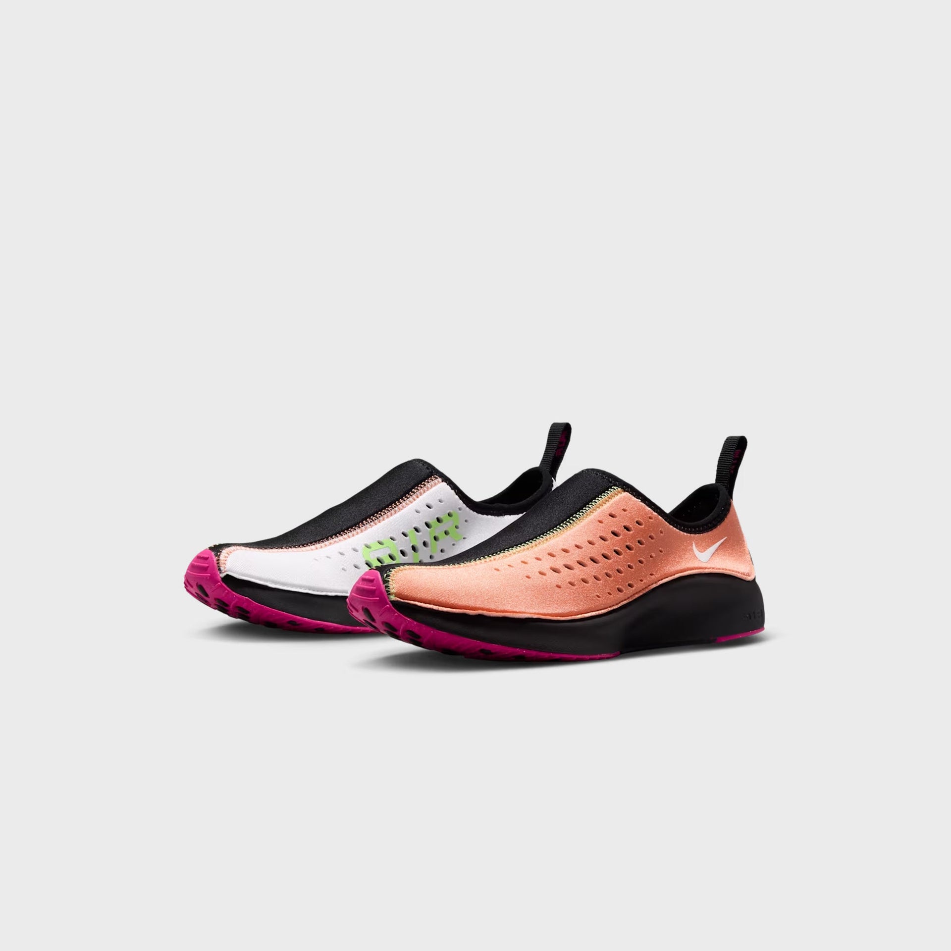 Mismatched pair of Nike WMNS Air Superfly Slip Neo SP slip-ons, orange frost left shoe and white right shoe with pink prime outsoles